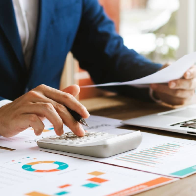 Finacial professional analyzing charts and using a calculator
